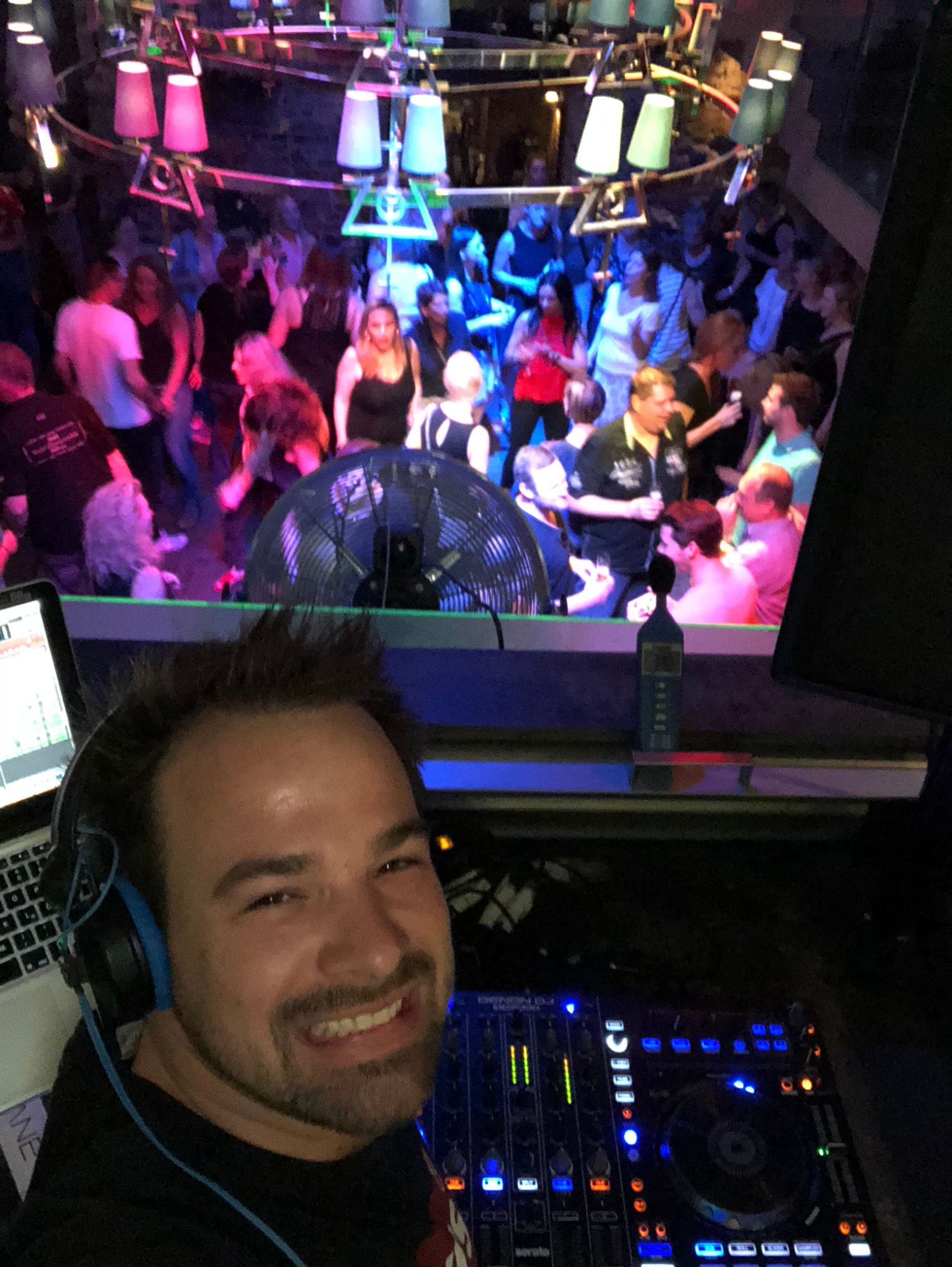 René Braun mit Blick über die Spiegelkugel auf eine volle Tanzfläche im Club