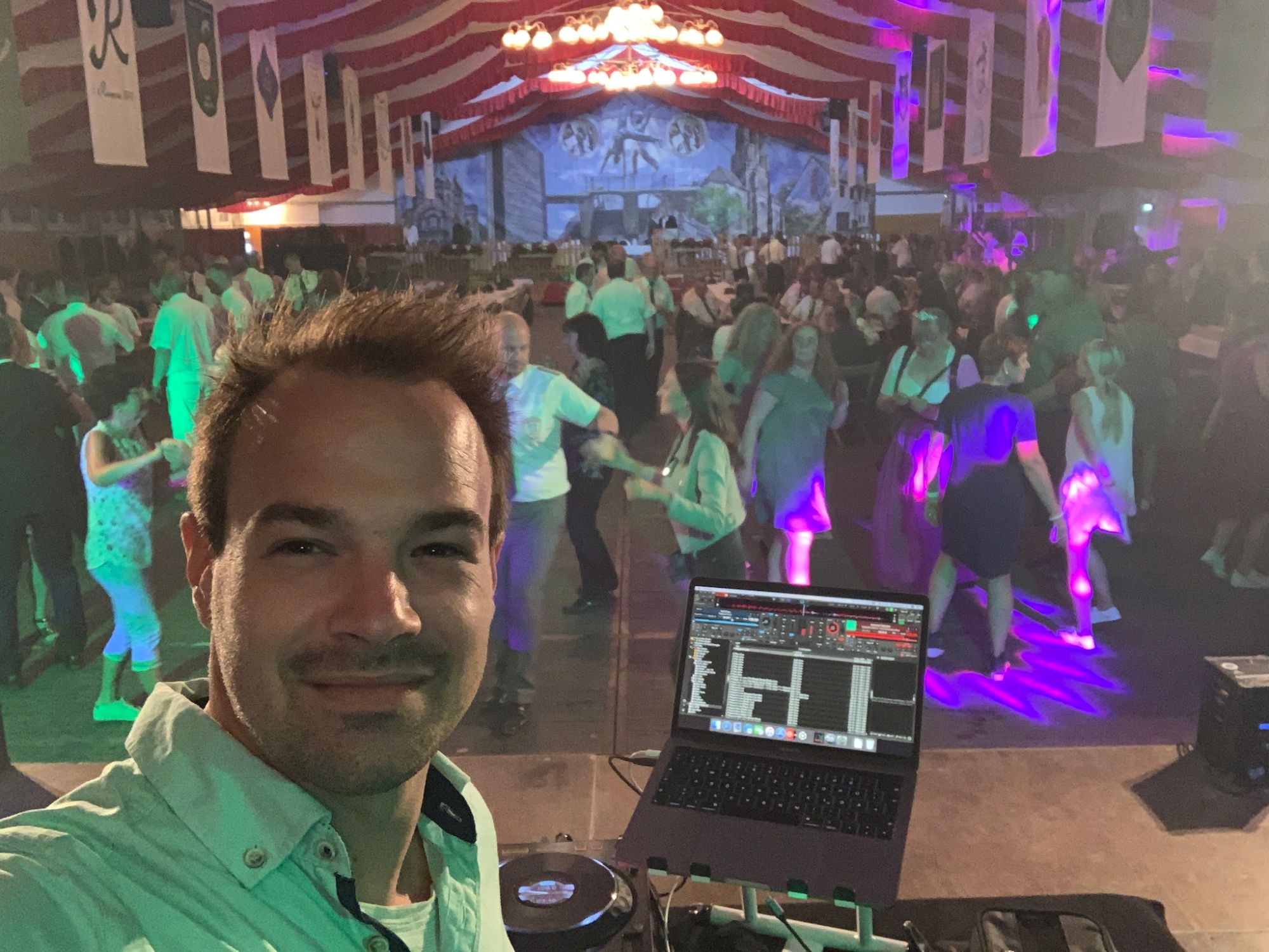 Selfie von René Braun am Pult, dahinter eine volle Tanzfläche im Festzelt beim Schützenfest